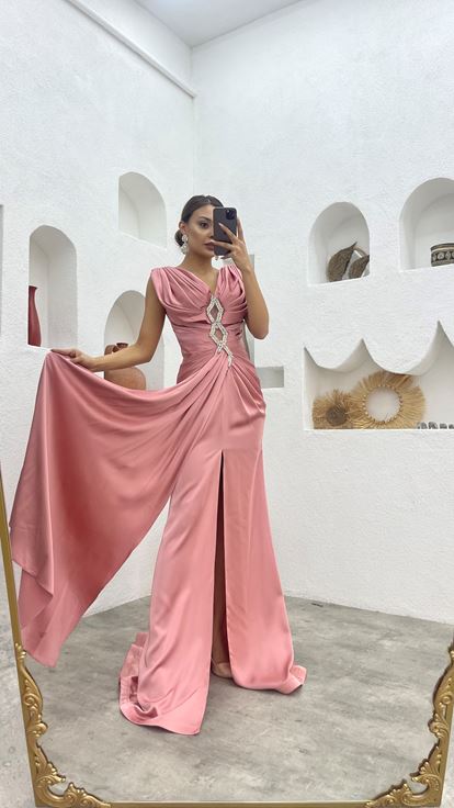 فستان سهرة وردي فاتح بتصميم مكشكش مع تفاصيل عند الخصر وتطريز