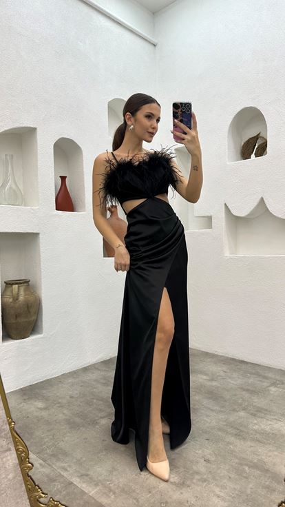 Robe de soirée noire en satin à fines bretelles et détail de plumes à la taille