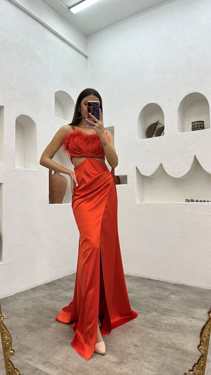 Vestido de noche naranja de satén con tirantes y detalle de plumas en la cintura 