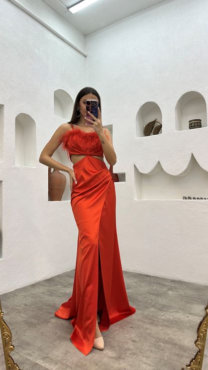 Vestido de noche naranja de satén con tirantes y detalle de plumas en la cintura 