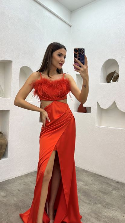 Vestido de noche naranja de satén con tirantes y detalle de plumas en la cintura 