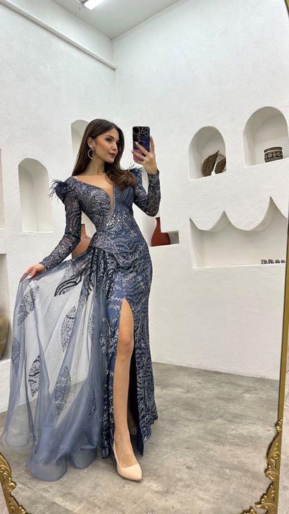 فستان سهرة من التول باللون الأزرق الداكن مزين بتفاصيل من الريش المطرز