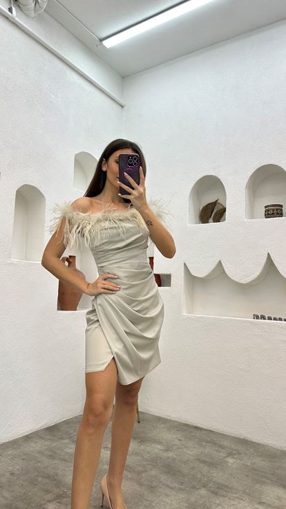 فستان سهرة من الساتان البيج مزين بتفاصيل من الريش ومُكشكش