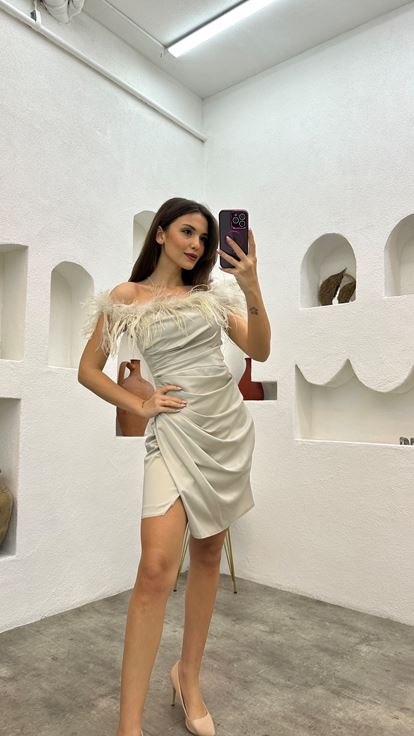 فستان سهرة من الساتان البيج مزين بتفاصيل من الريش ومُكشكش