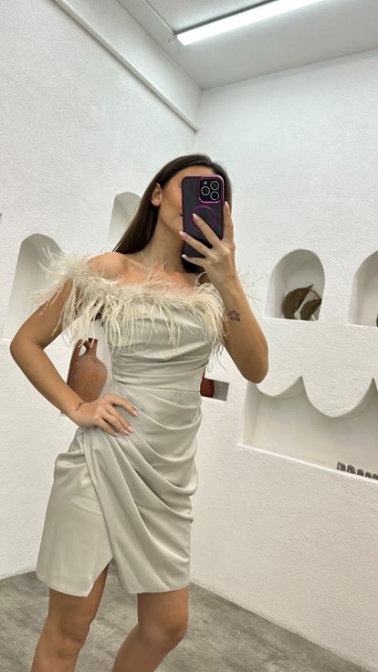 فستان سهرة من الساتان البيج مزين بتفاصيل من الريش ومُكشكش