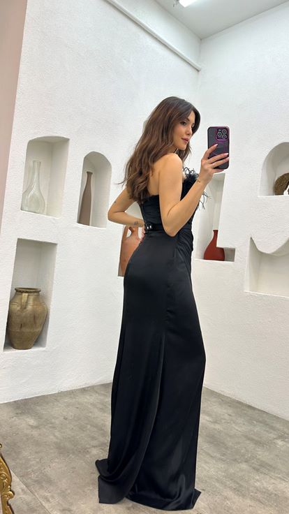 Abito da sera in raso nero con dettagli in piume e cintura drappeggiata 