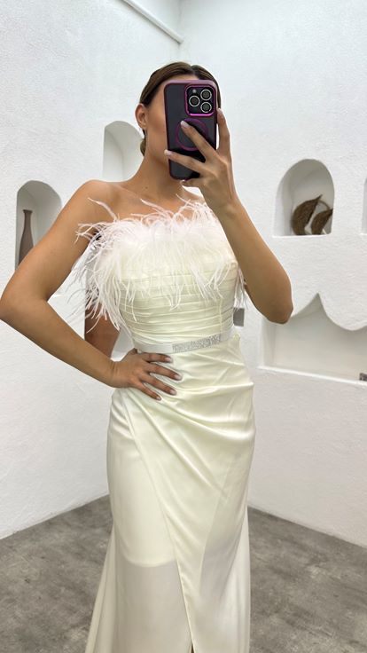 فستان سهرة أبيض من الساتان مزين بتفاصيل من الريش وحزام منسدل