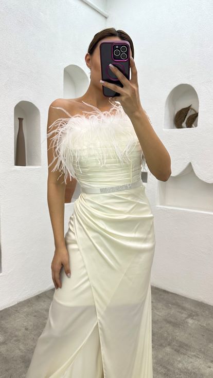 فستان سهرة أبيض من الساتان مزين بتفاصيل من الريش وحزام منسدل