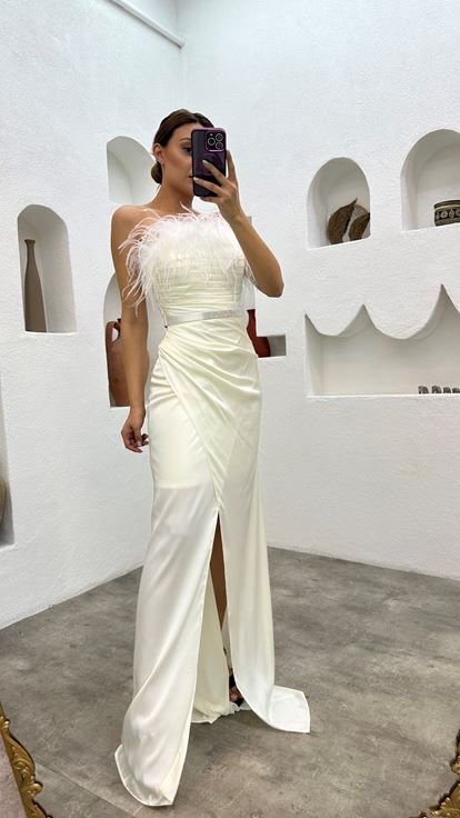 فستان سهرة أبيض من الساتان مزين بتفاصيل من الريش وحزام منسدل