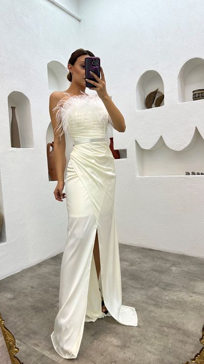 فستان سهرة أبيض من الساتان مزين بتفاصيل من الريش وحزام منسدل