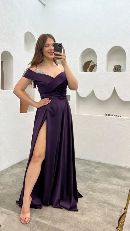 فستان سهرة من الساتان بلون البرقوق مزين بأحجار كريمة على الصدر والحزام 