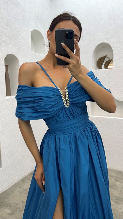 Blaues Abendkleid mit Seilträgern und Steinen auf der Brust