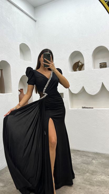 Schwarzes  mit Ballonärmeln und Verzierungen versehenes Abendkleid mit Schlitz