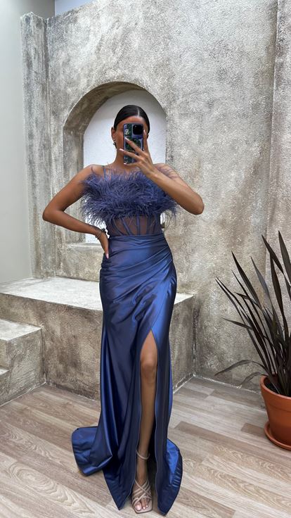 فستان سهرة من الساتان الأزرق الداكن بحمالات رفيعة وتفاصيل من الريش على الصدر والخصر