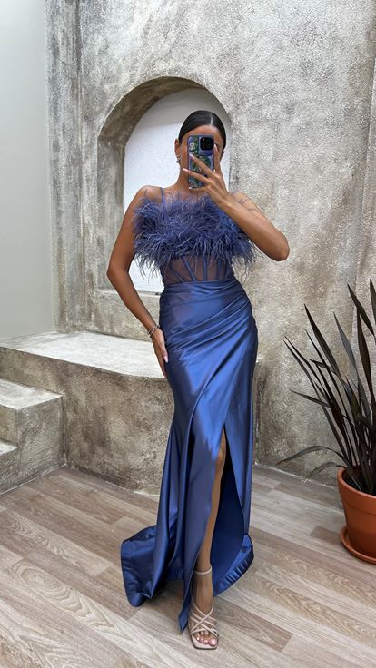 فستان سهرة من الساتان الأزرق الداكن بحمالات رفيعة وتفاصيل من الريش على الصدر والخصر