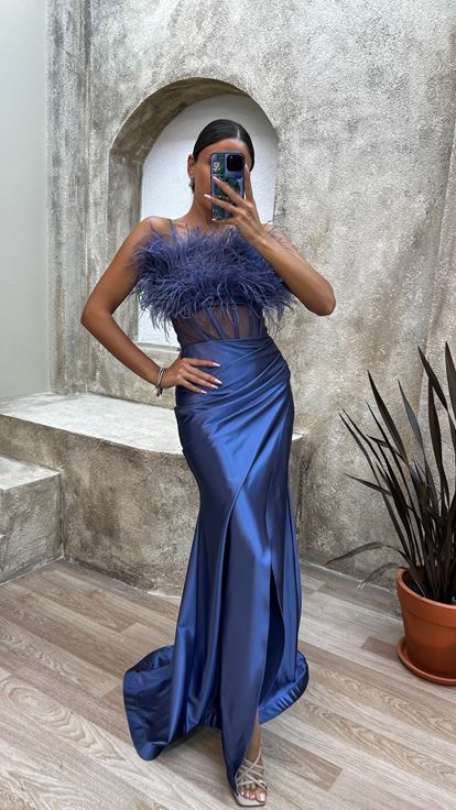 فستان سهرة من الساتان الأزرق الداكن بحمالات رفيعة وتفاصيل من الريش على الصدر والخصر