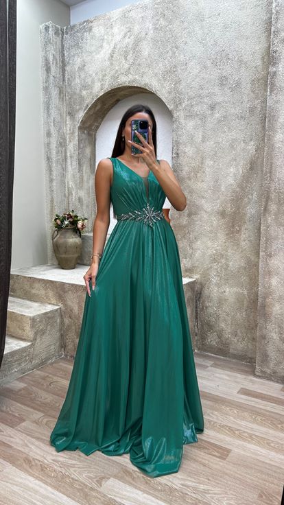Vestido de noche verde con detalle en la espalda y drapeado  adornado con piedras en la cintura 