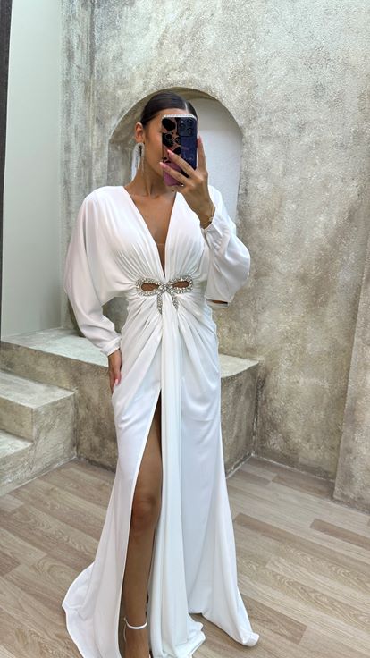 فستان سهرة أبيض بياقة على شكل حرف V مزين بتفاصيل عند الخصر وفتحة جانبية