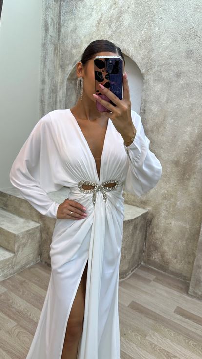 فستان سهرة أبيض بياقة على شكل حرف V مزين بتفاصيل عند الخصر وفتحة جانبية