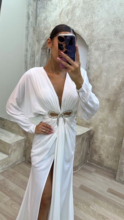 فستان سهرة أبيض بياقة على شكل حرف V مزين بتفاصيل عند الخصر وفتحة جانبية