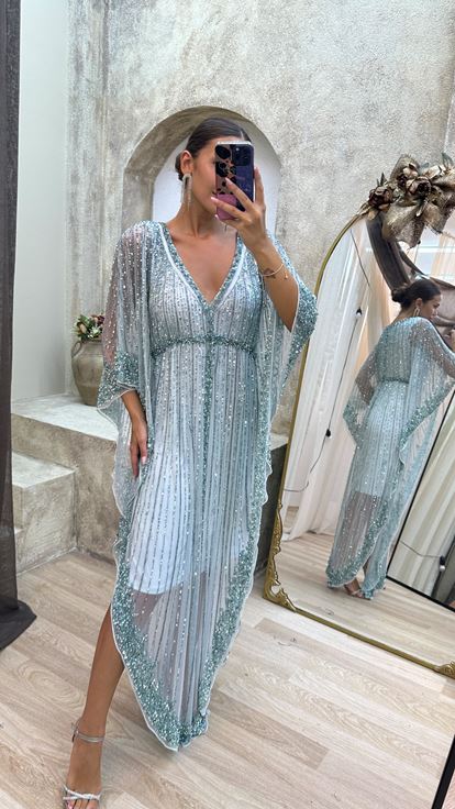 فستان مطرز يدوياً بتصميم خاص، بأكمام واسعة بلون الفيروز