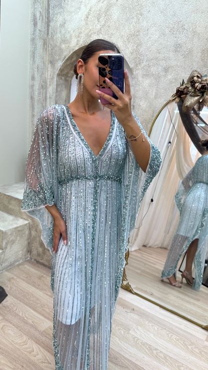 فستان مطرز يدوياً بتصميم خاص، بأكمام واسعة بلون الفيروز