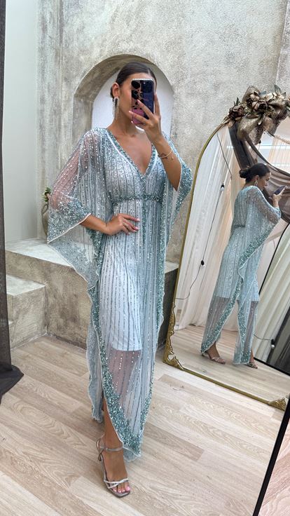 فستان مطرز يدوياً بتصميم خاص، بأكمام واسعة بلون الفيروز