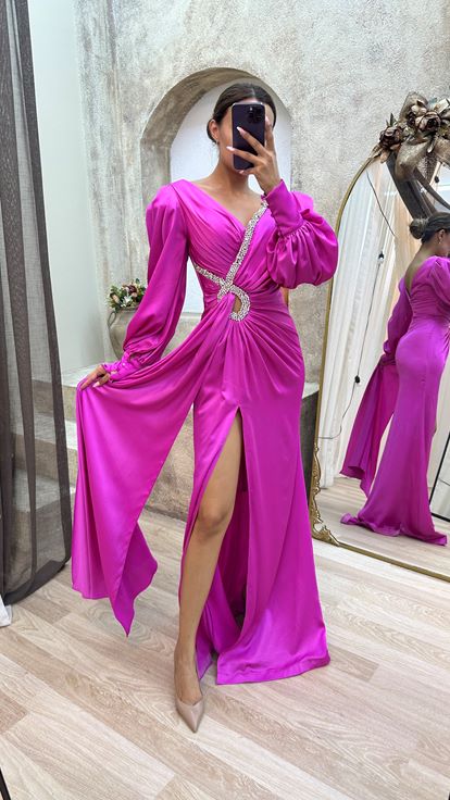 فستان سهرة بلون الفوشيا بياقة على شكل حرف V وتفاصيل مطرزة وأكمام بالون بتصميم منسدل