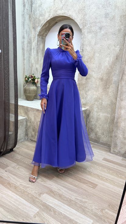 فستان سهرة من التول مزين بتفاصيل خصر بلون الليلك وكتفين مبطنتين وحجاب 