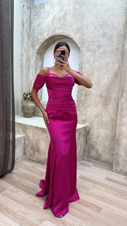 فستان سهرة من الساتان المطرز بلون الفوشيا، بأكمام مزينة بأشرطة وتفاصيل منسدلة 