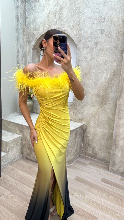 فستان سهرة أصفر بدون حمالات مزين بتفاصيل من الريش