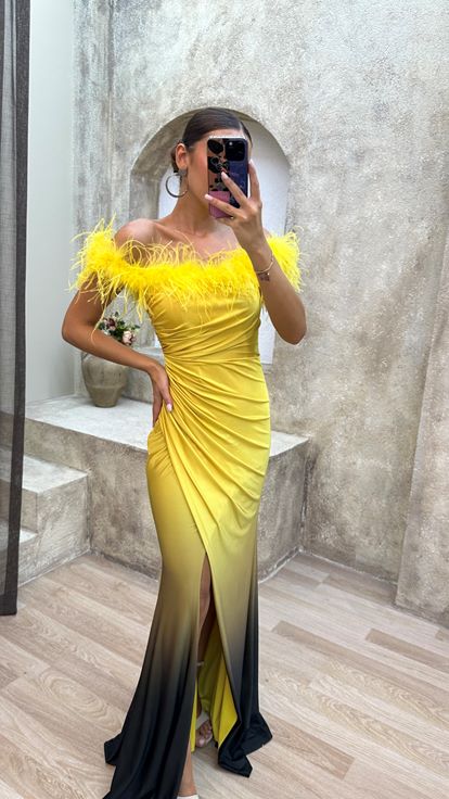 فستان سهرة أصفر بدون حمالات مزين بتفاصيل من الريش