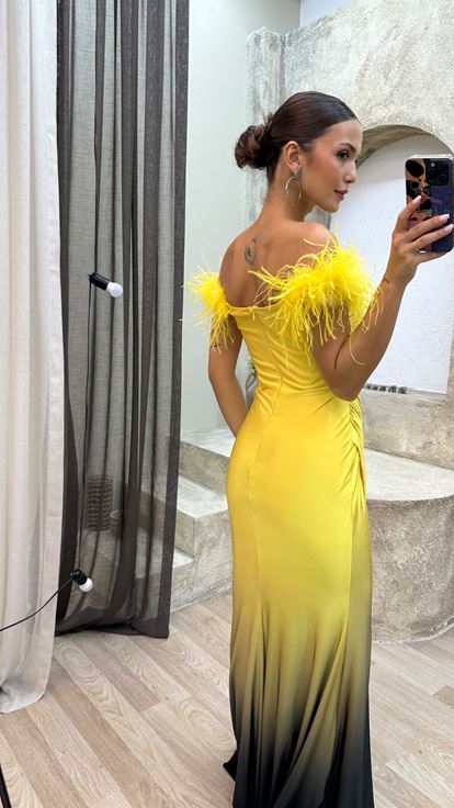 فستان سهرة أصفر بدون حمالات مزين بتفاصيل من الريش