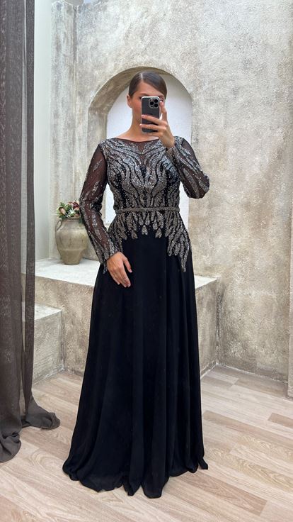 فستان سهرة أسود من الساتان بمقاسات كبيرة مع تفاصيل من التول على الصدر