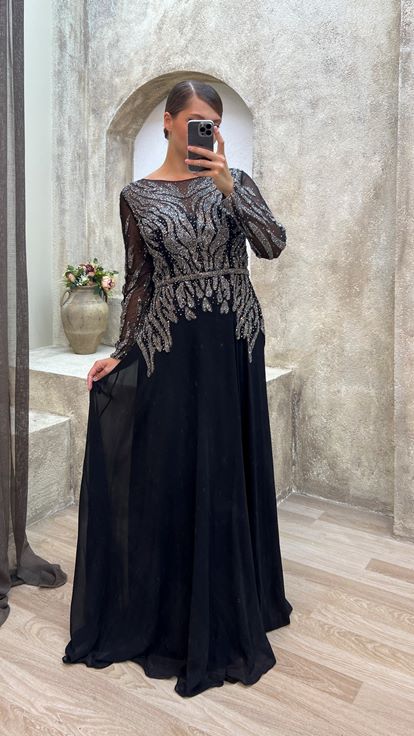 فستان سهرة أسود من الساتان بمقاسات كبيرة مع تفاصيل من التول على الصدر