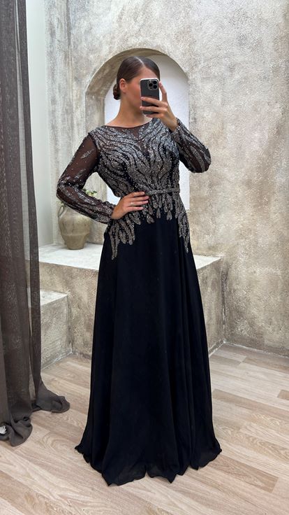 فستان سهرة أسود من الساتان بمقاسات كبيرة مع تفاصيل من التول على الصدر