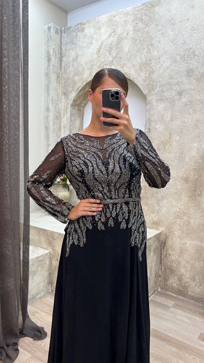 فستان سهرة أسود من الساتان بمقاسات كبيرة مع تفاصيل من التول على الصدر