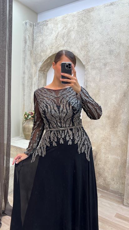 فستان سهرة أسود من الساتان بمقاسات كبيرة مع تفاصيل من التول على الصدر