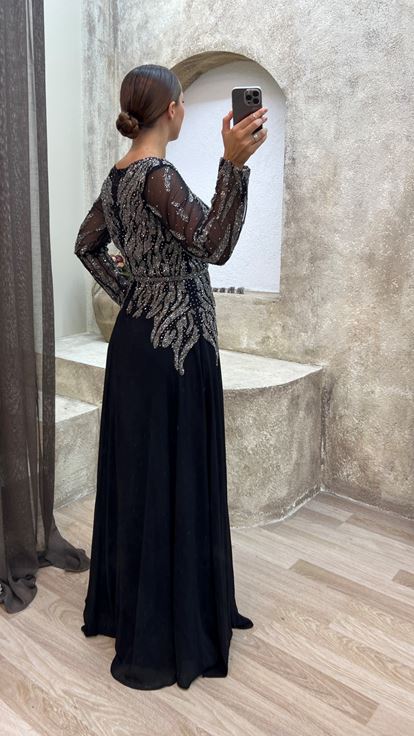 فستان سهرة أسود من الساتان بمقاسات كبيرة مع تفاصيل من التول على الصدر