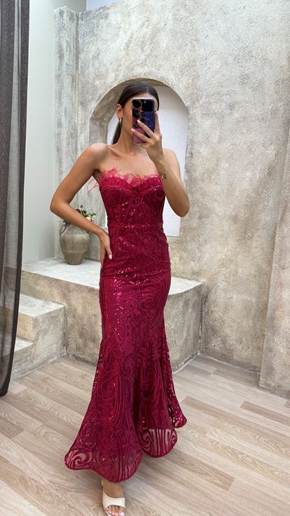 Abito di paillettes rosso senza spalline con piuma di piume