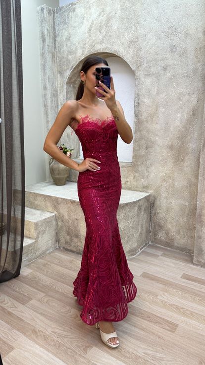 Abito di paillettes rosso senza spalline con piuma di piume