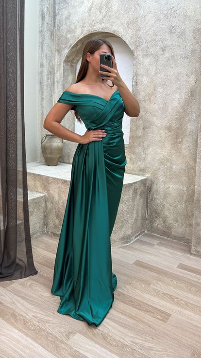 فستان سهرة أخضر من الساتان بمقاسات كبيرة، بياقة قارب وتفاصيل عند الخصر 