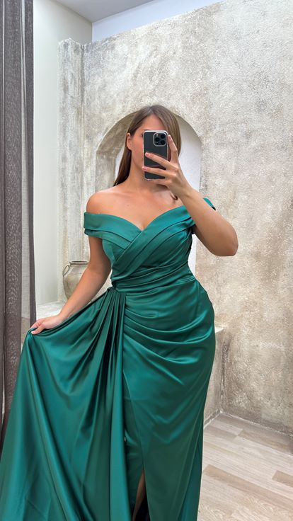 فستان سهرة أخضر من الساتان بمقاسات كبيرة، بياقة قارب وتفاصيل عند الخصر 