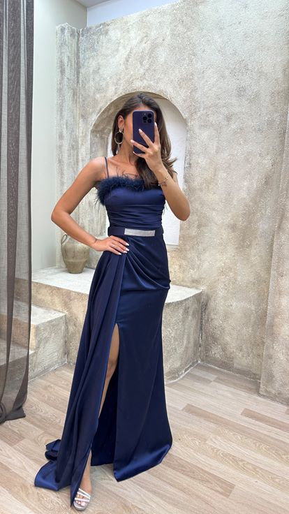 Vestido de noche azul marino con tirantes y detalle de plumas en el busto y el cinturón 