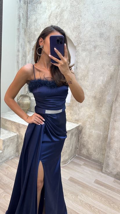 Vestido de noche azul marino con tirantes y detalle de plumas en el busto y el cinturón 