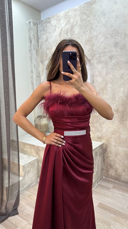 فستان سهرة بدون حمالات بلون عنابي مزين بتفاصيل من الريش على الصدر