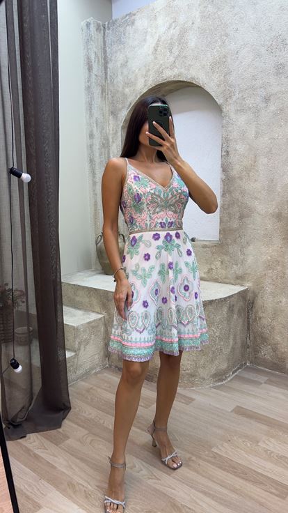 فستان أبيض بتصميم خاص مطرز ومزين بشراشيب