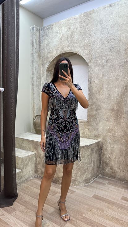 فستان أسود مزين بشراشيب في الجزء العلوي والتنورة، بتصميم مطرز مميز 