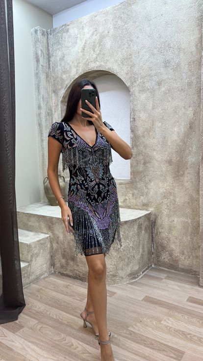 فستان أسود مزين بشراشيب في الجزء العلوي والتنورة، بتصميم مطرز مميز 