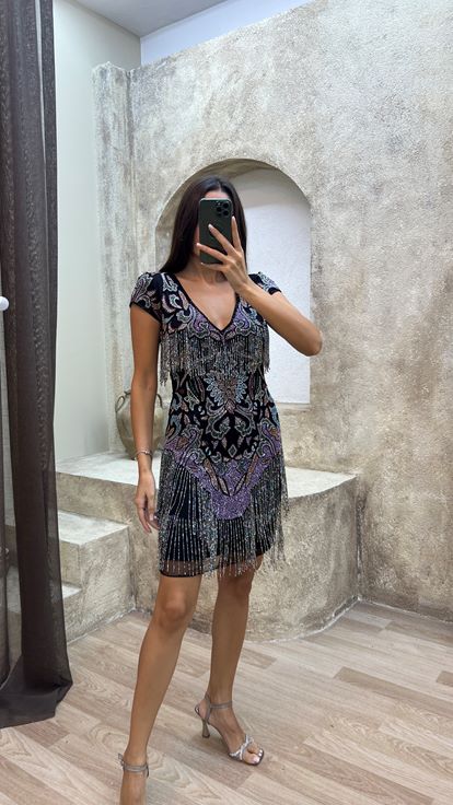 فستان أسود مزين بشراشيب في الجزء العلوي والتنورة، بتصميم مطرز مميز 